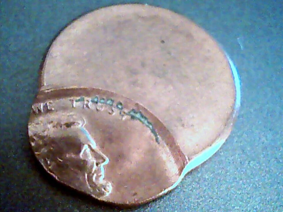 Off-center Lincoln cent with a displaced design and a portion of the planchet left unstruck
