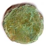 Corroded Roman coin with green deposits and a worn portrait